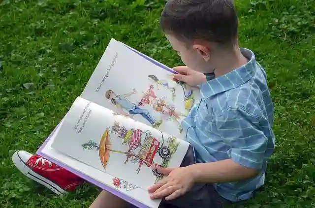 芝生で絵本を読む男の子